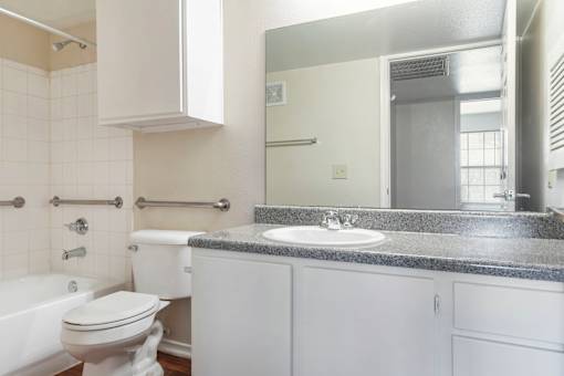 A white bathroom with a tub, toilet, and sink.