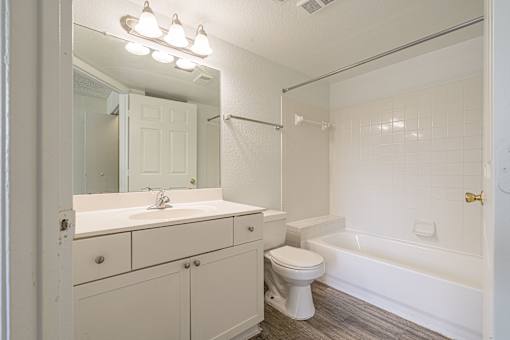 A white bathroom with a toilet, sink, and bathtub.