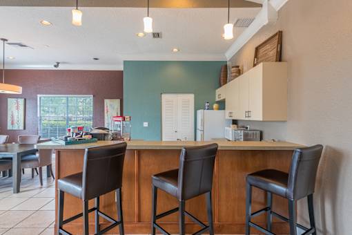 A kitchen with a bar area and two chairs.