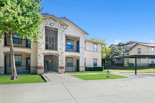 A building with a stone facade and a tree in front.