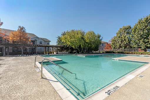 A swimming pool with a glass barrier and a sign that says 3R.