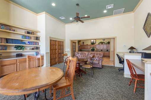 A room with a round wooden table surrounded by chairs.