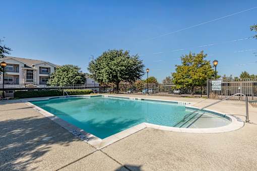 A large outdoor swimming pool surrounded by a fence.
