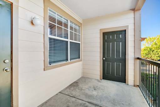 A black door is on the right side of a white wall.