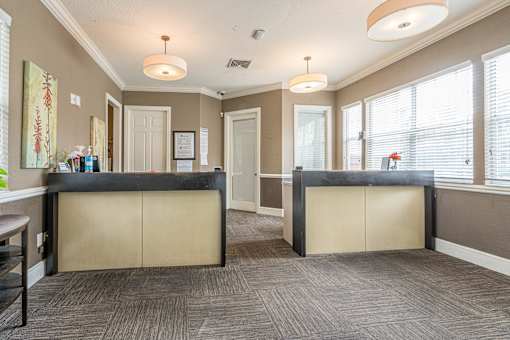 A reception area with a black counter and beige walls.