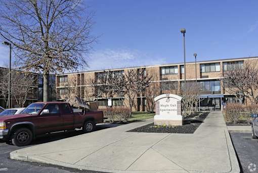 Maple Oaks Apartments is a large apartment complex with a parking lot in front.
