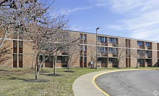 A large building with a parking lot in front.