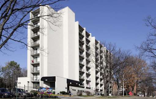 A tall white building with balconies on the side.