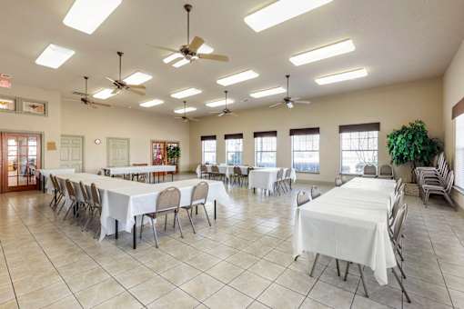 A large room with tables and chairs set up for an event.
