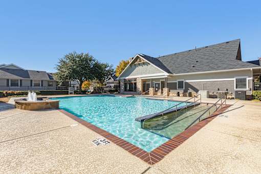 A swimming pool in front of a house.