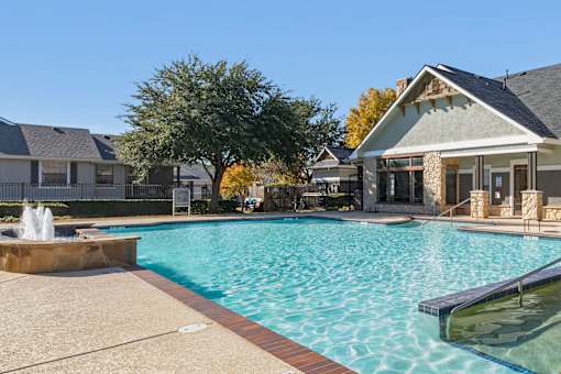 A swimming pool with a fountain in the middle of it.