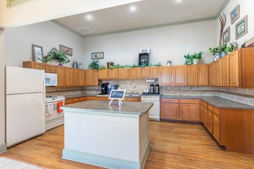 A kitchen with wooden cabinets and a white island.