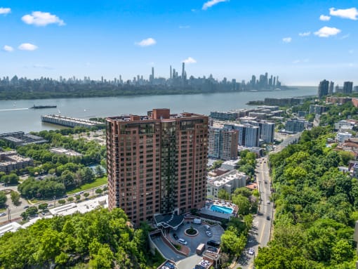 an aerial view of an apartment building with the city in the background at Riello Apartments Owner LLC, Edgewater, NJ