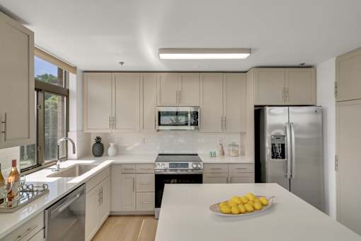 A kitchen with a bowl of lemons on the counter.
