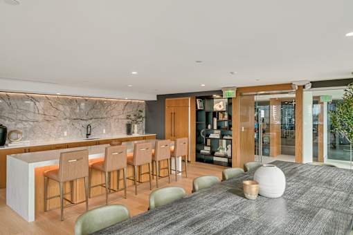 A modern kitchen with a bar area and a dining table.