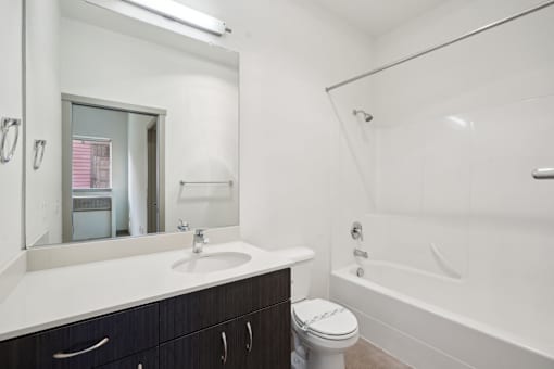 A white bathroom with a toilet, sink, and bathtub.