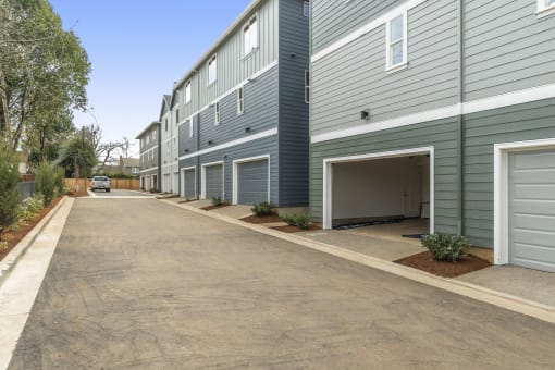 an empty parking lot in front of a building with a garage door open