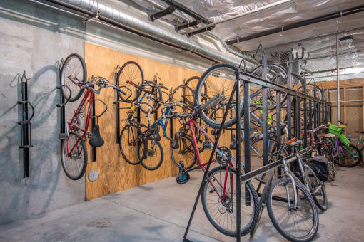 a collection of bikes hanging on a wall in a garage