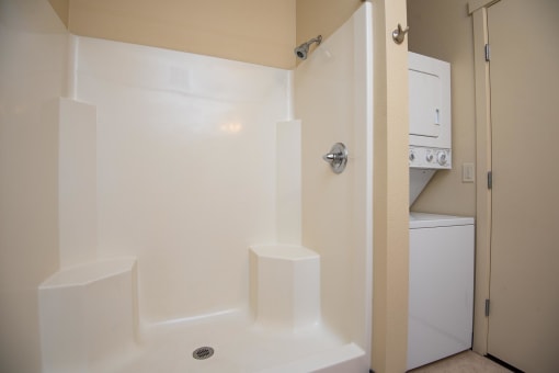 a bathroom with a shower and a washing machine in it
