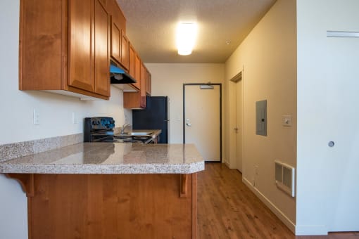 a kitchen with a granite counter top and wood cabinets
