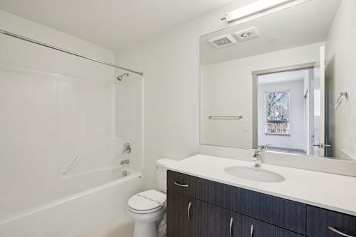 A white bathroom with a sink, toilet, and bathtub.