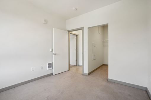 A room with a white door and a white wall.