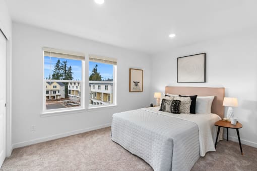 a bedroom with a bed and two windows