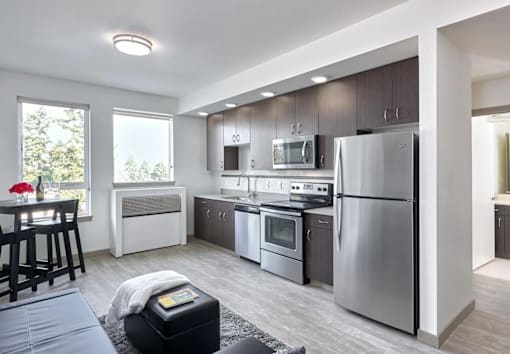 A modern kitchen with stainless steel appliances and wooden cabinets.