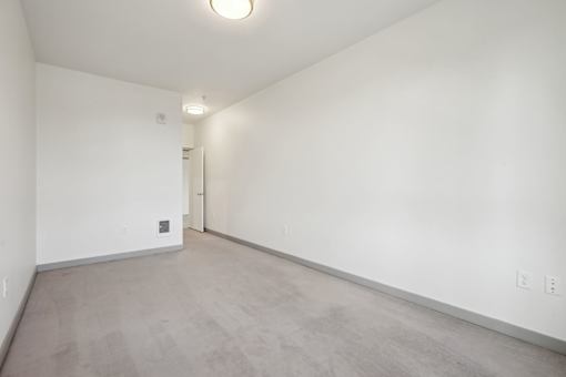 A large empty room with a door on the left side.