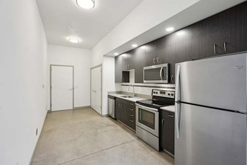 A kitchen with stainless steel appliances and a white refrigerator.