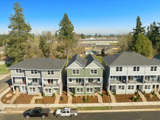an aerial view of a group of houses with cars parked in front of them