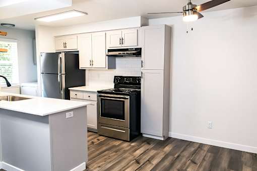 A kitchen with a black refrigerator, stove, and oven.
