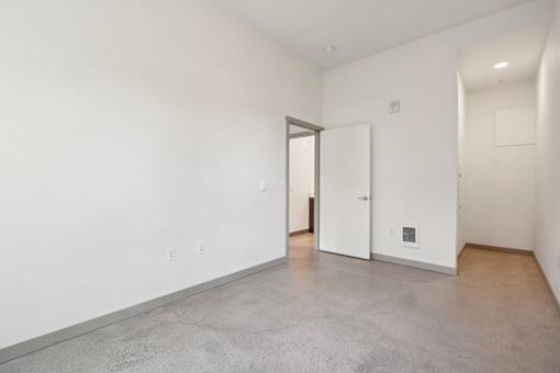 A large empty room with a doorway leading to another room.