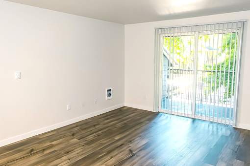 A room with a sliding glass door leading to a balcony.