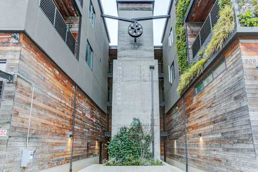 the clock tower in the middle of a alley between two buildings