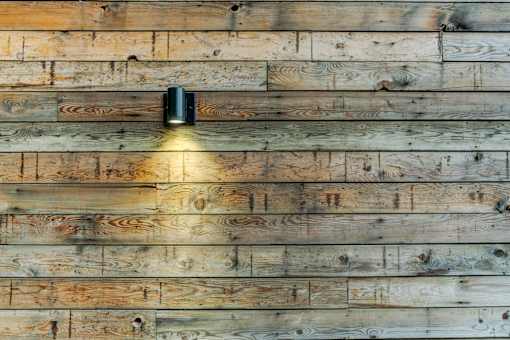 the wall is made of reclaimed wood with a light on it