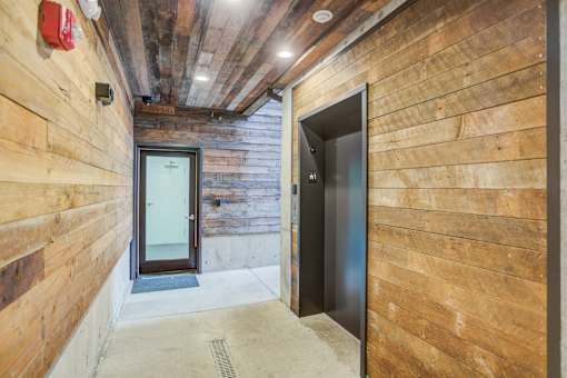 a hallway with two doors in a wood walled building