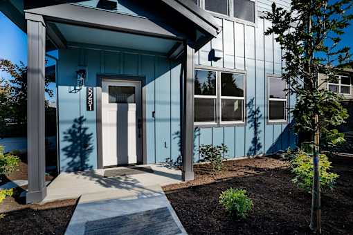 A blue house with a white door and windows.