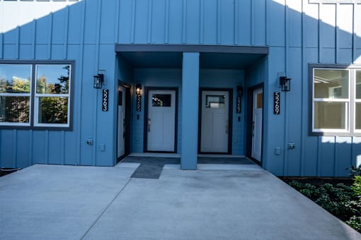 A blue building with a white door and windows.