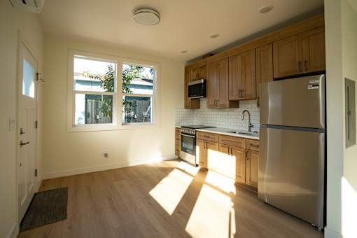 A kitchen with wooden cabinets and a stainless steel refrigerator.