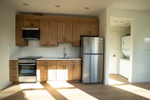 A kitchen with wooden cabinets and a stainless steel refrigerator.