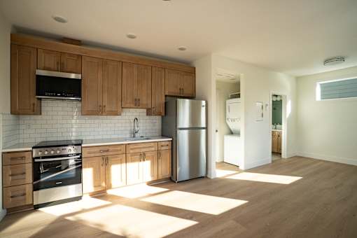 A kitchen with wooden cabinets and a stainless steel refrigerator.