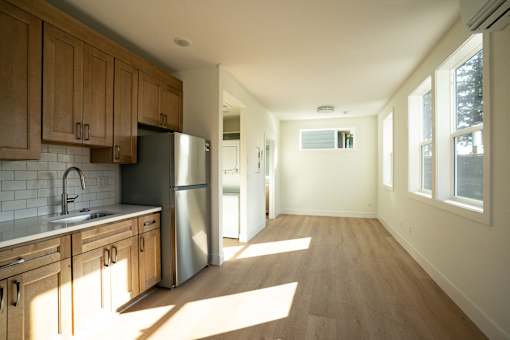 A kitchen with wooden cabinets and a stainless steel refrigerator.