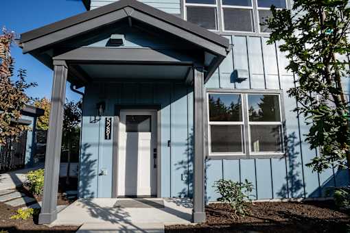 A blue house with a white door and windows.
