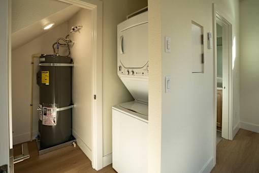 A room with a white cabinet and a wall-mounted oven.