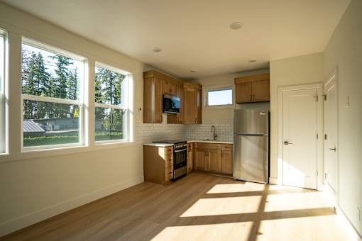 A kitchen with wooden cabinets and a stainless steel refrigerator.