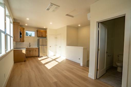 A kitchen with wooden floors and white walls.