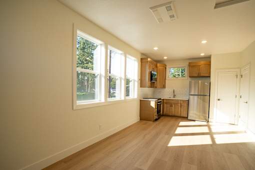 A kitchen with wooden floors and white walls.