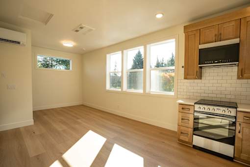 A kitchen with a stove top oven and wooden cabinets.