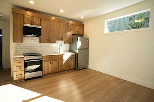 A kitchen with wooden cabinets and a stainless steel refrigerator.